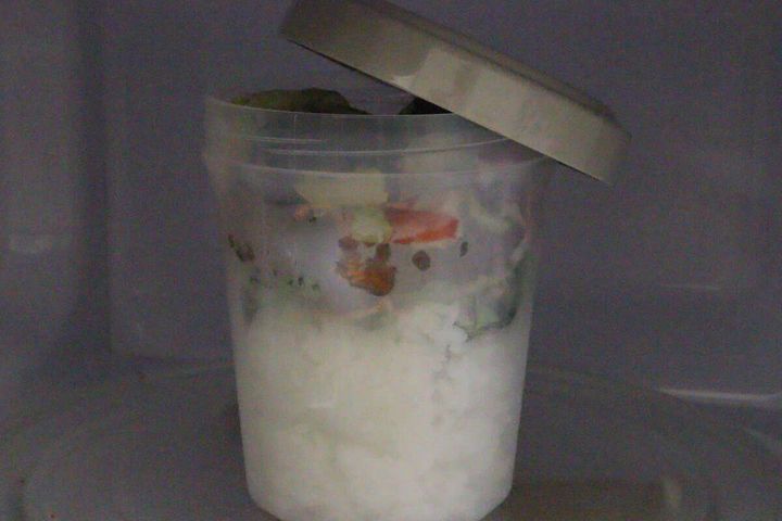 フタを少しずらして電子レンジの庫内に入れているカップ型ランチボックス