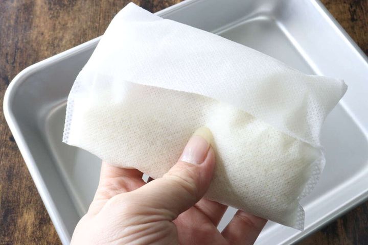 お米を入れた不織布の袋の口を折り返して閉じている様子