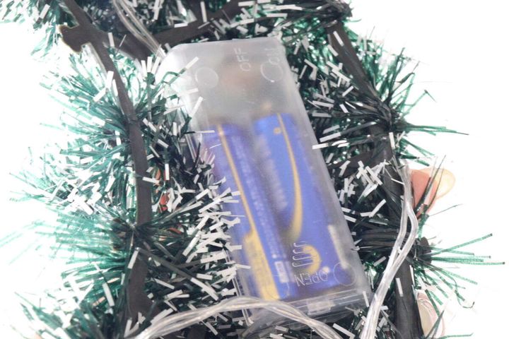 クリスマスリースに隠された電池ボックス。単三電池が2本入っているのが透けて見える。