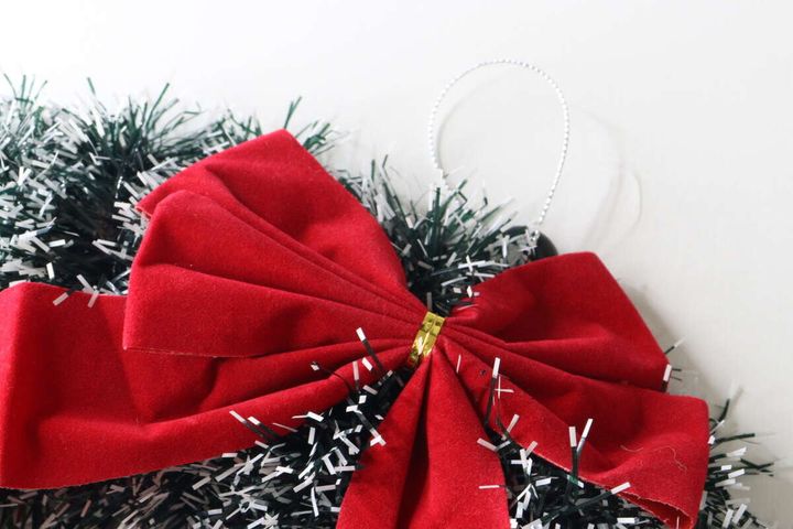 クリスマスリースに付いている赤いリボンのアップ。リボンの中心部分とモールの質感がわかる。