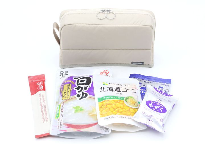 ベージュのポーチの前に、ポーチに収納されていたレトルト食品やフリーズドライ食品が並べられている