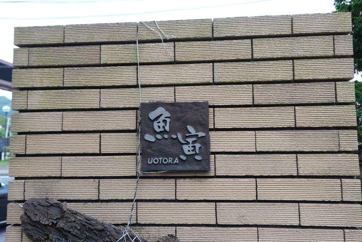 魚寅のロゴが刻印された店先の看板