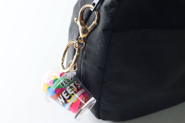 黒いリュックのファスナーにカニカンで取り付けられたキーホルダー