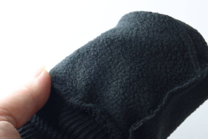 指で黒い防寒手袋の内側のモコモコした素材を触っているクローズアップ