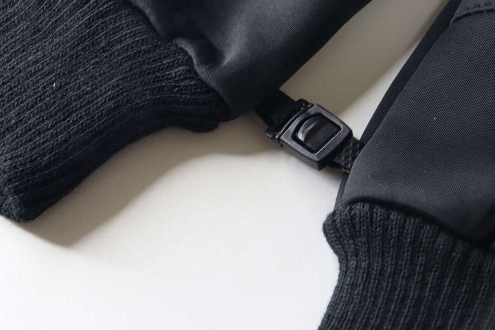 黒い防寒手袋2つを連結するプラスチック製のバックル部分のクローズアップ