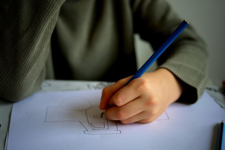 色鉛筆で、紙に絵を描く手です。今回の調査では、作品の評価で全体として大人が子どもを上回りました。