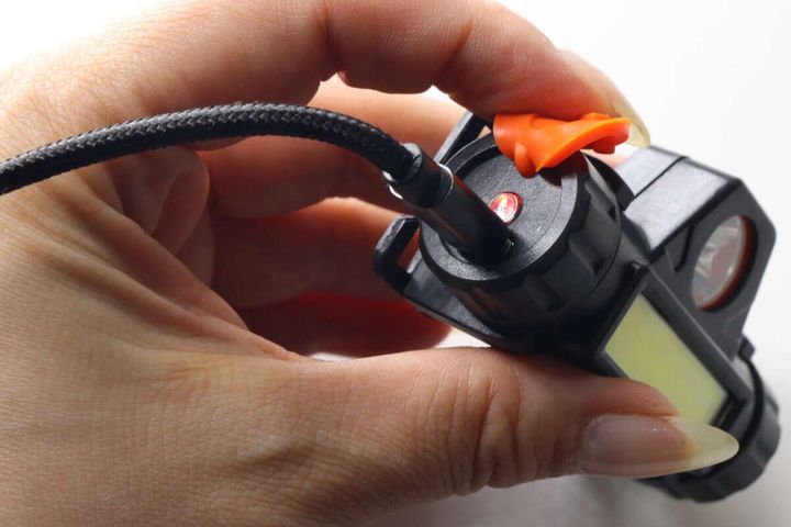 黒い本体の端子にUSBケーブルを挿して充電している様子