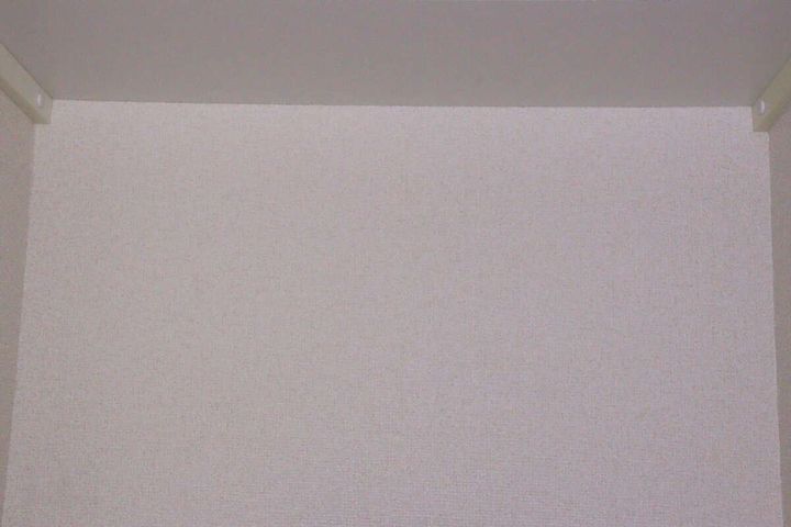 薄暗い室内の壁面を広角モードで広く照らしている状態