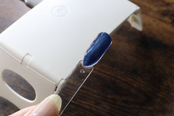 レジンライトでしっかりと硬化されたネイルチップを見せている様子
