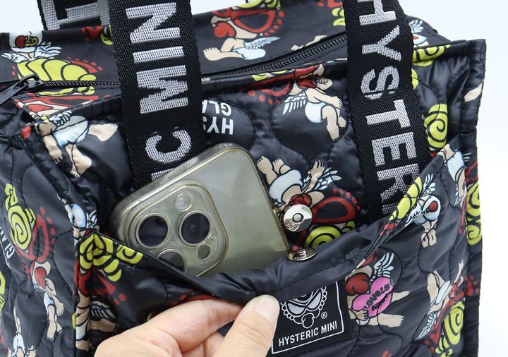 ヒステリックミニの黒いキルティングバッグのフロントポケットにスマホを収納している様子