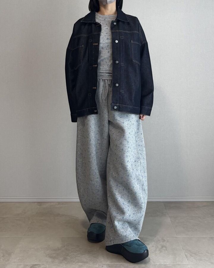 グレーのリブTシャツにスウェットパンツとデニムジャケットを合わせた全身写真