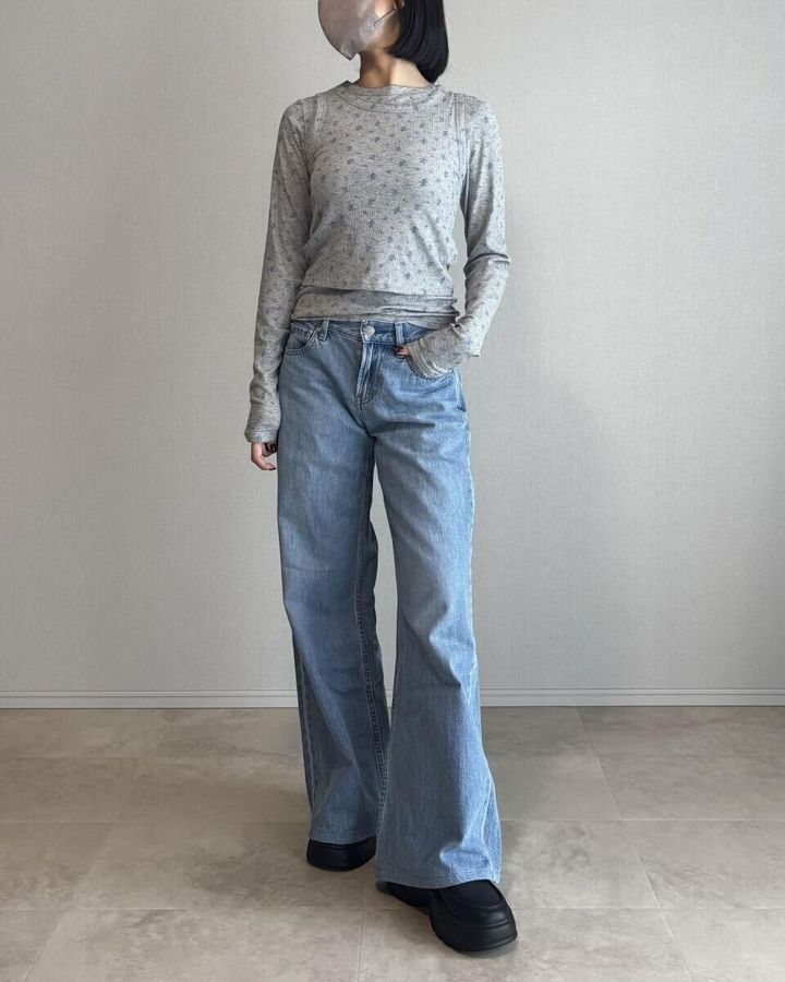 グレーのリブTシャツに淡いブルーのワイドデニムを合わせたコーディネート写真
