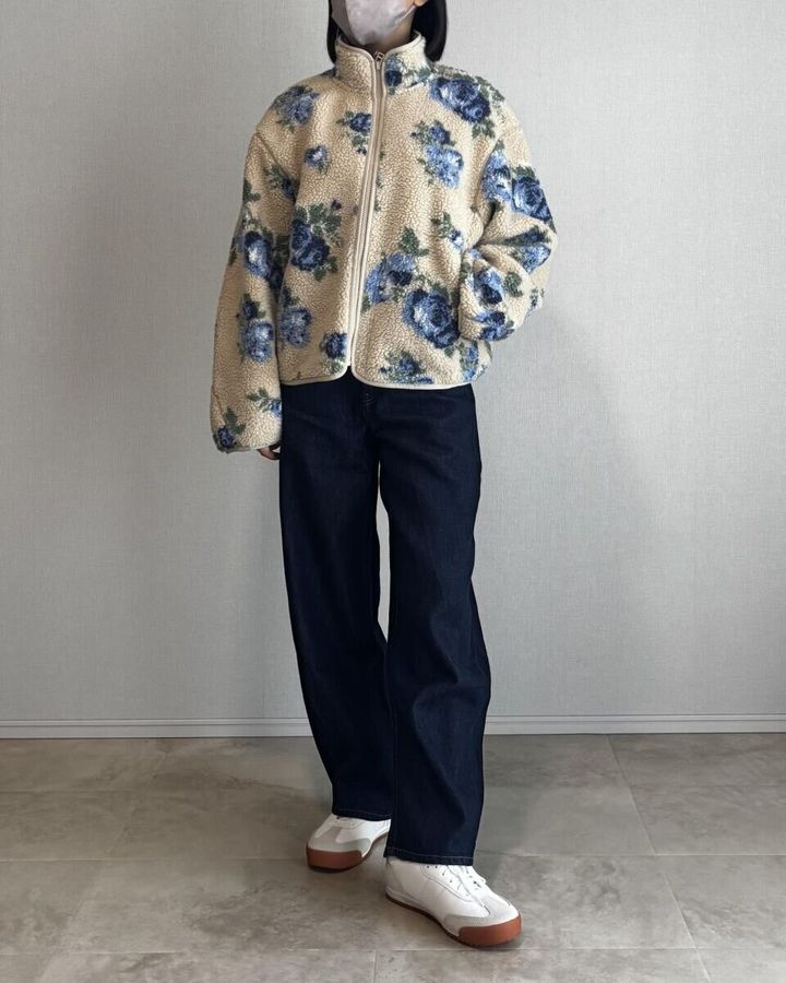 ベージュの花柄フリースジャケットにネイビーのバレルレッグデニムを合わせた全身写真