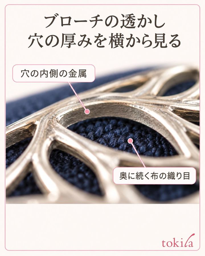 ブローチの透かし穴の金属の側壁と、その奥に見える紺の布の織り目