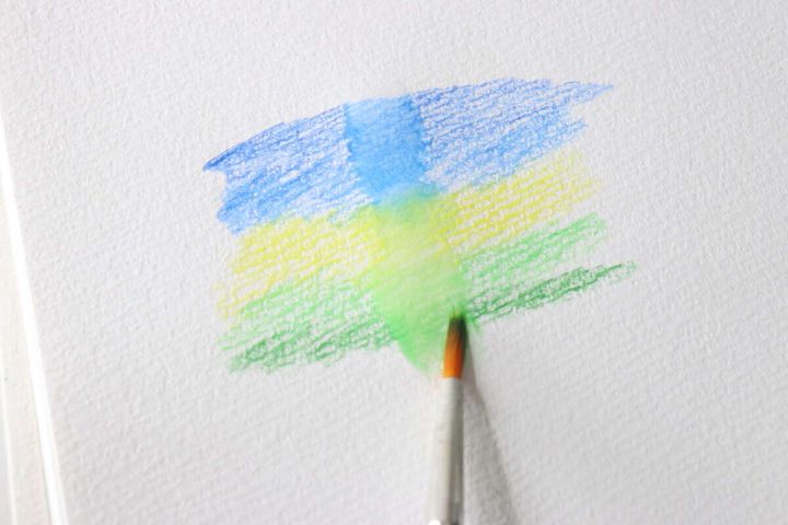 水を含んだ筆で画用紙の試し描き部分をなぞりぼかしている様子