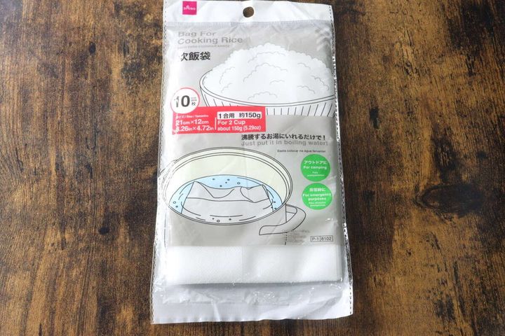木目のテーブルの上に置かれたダイソーの炊飯袋のパッケージ表面