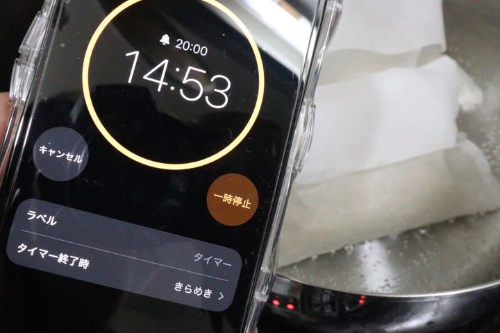 茹で時間を測るためにスマートフォンのタイマー画面を鍋にかざしている様子