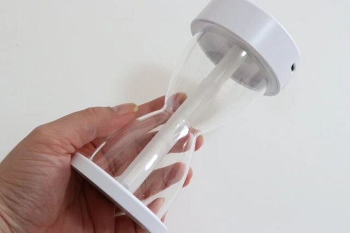 手に持って砂時計型デザインを確認している加湿器の全体像