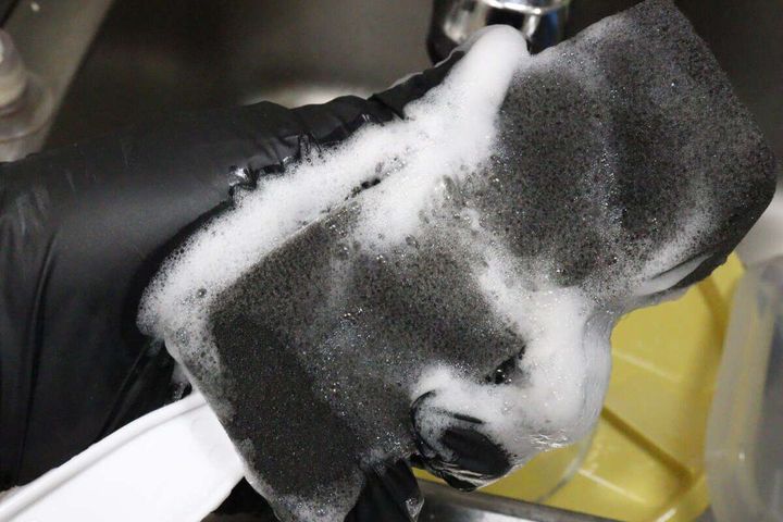 黒いスポンジに洗剤を含ませてしっかりと泡立てているところ