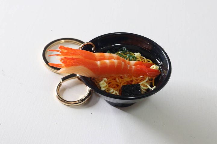 黒いお椀に入った巨大なえび付きうどんキーホルダーの斜め上からの写真
