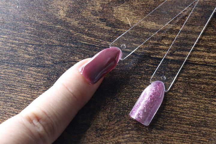 完成したカラーチャートスティックを爪にあてがって色味を確認している様子