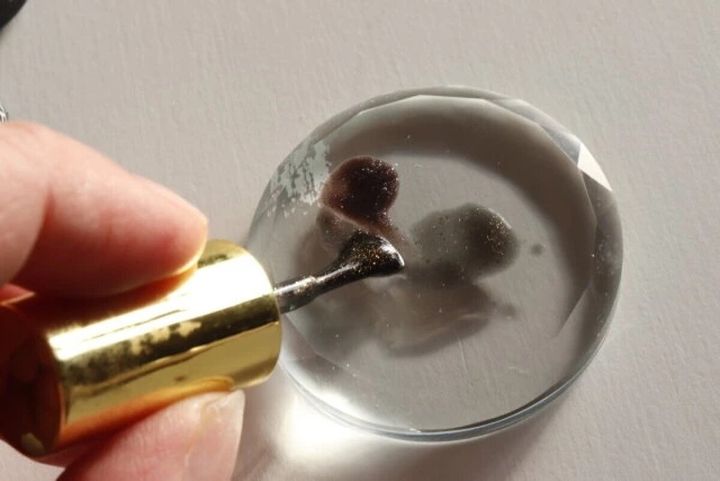 ガラスパレットの上で筆を使いジェルネイルを混ぜ合わせている様子
