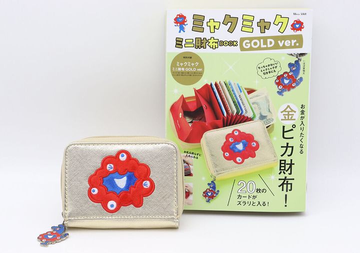 ゴールドのミャクミャクミニ財布と、付録付きムック本「ミャクミャク ミニ財布BOOK GOLD ver.」が並べられている