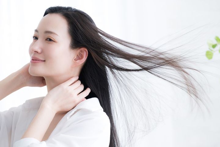 女性の流れる長い黒髪のヘアケアや美容のビューティーイメージ 風になびく女性