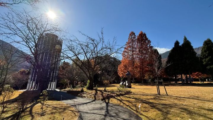 塔と彫刻と、色づいた木のある風景