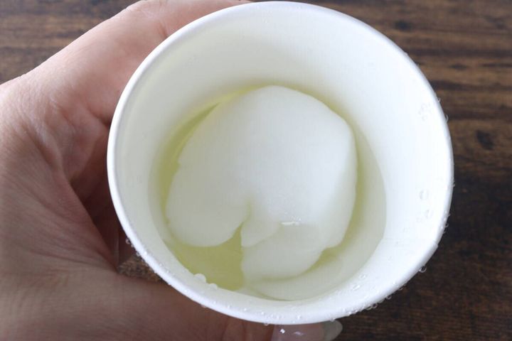紙コップの水に浸された圧縮タオルが数秒で大きく膨らんでいる様子