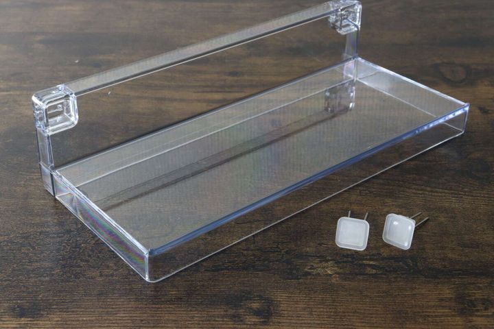 木目のテーブルの上に置かれた透明なディスプレイトレーと専用のピン2個