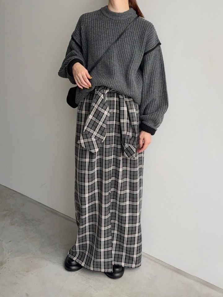 チェック柄シャツワンピースの腰にグレーのニットを巻きスカート風に結んだ女性