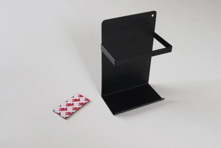 黒いマグネット式のラップホルダーと付属の粘着シートの俯瞰写真