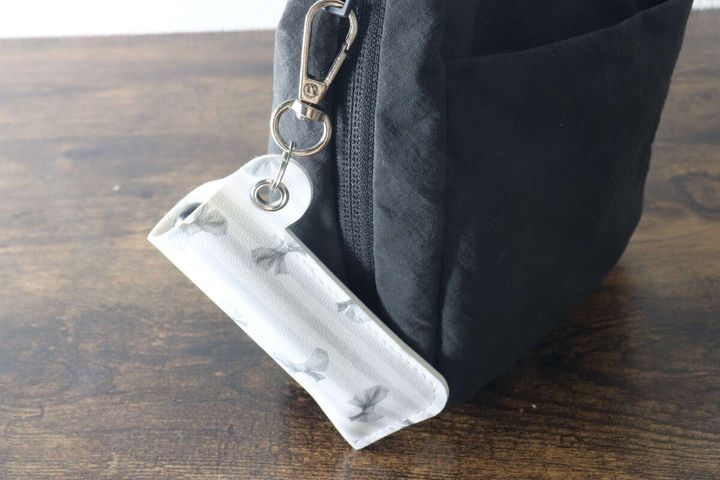 黒いバッグの金具にリップホルダーを取り付けている様子