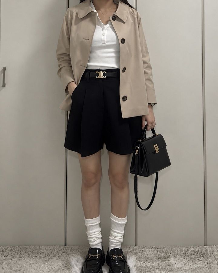 ベージュのジャケットと黒のショートパンツに白ソックスとローファーを合わせた全身