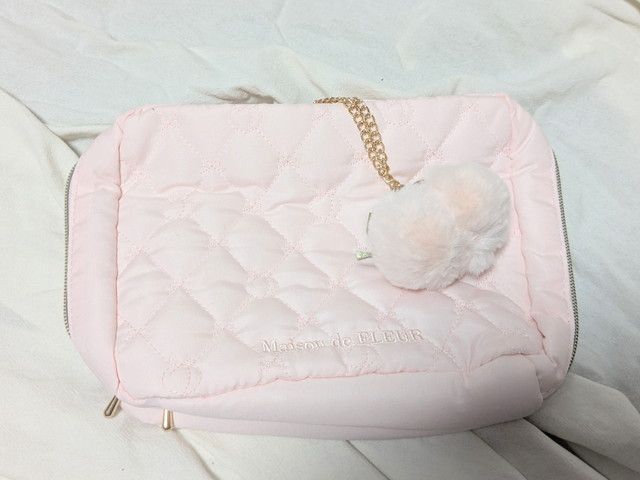 ファーの桃チャームが付いたピンクのキルティングケース