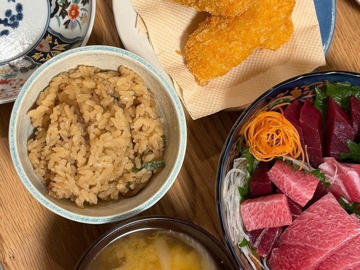 無印良品の牛しぐれ煮の五目ごはんを茶碗に盛り付けた食卓。刺身や揚げ物、味噌汁とともに並べた夕食。