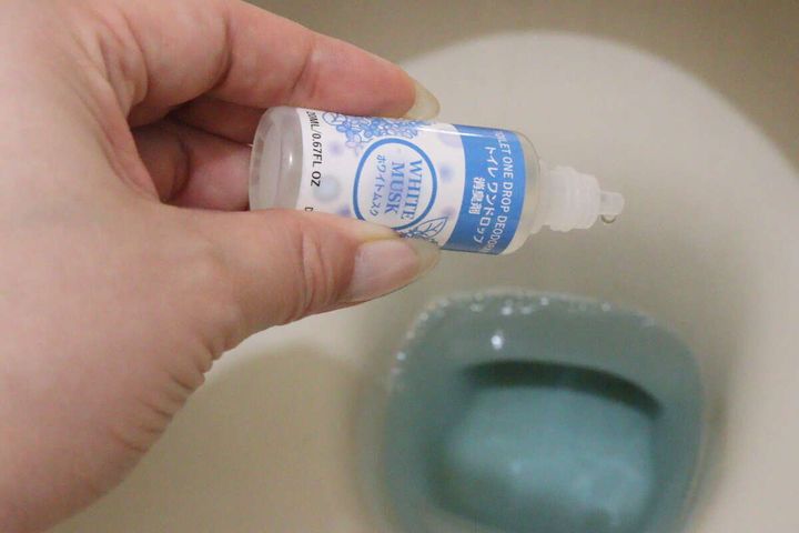 便器の水たまり部分に消臭剤の液体を垂らしている様子