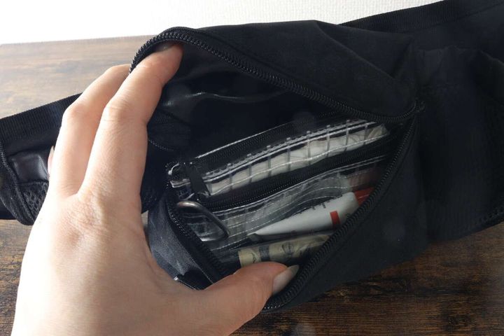 メインのファスナーポケットに小物を収納している様子