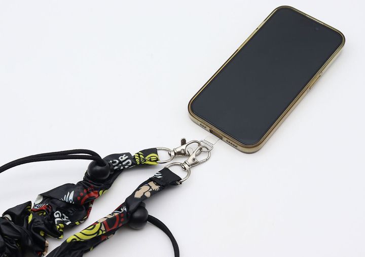 スマートフォンにショルダーストラップのナスカンを取り付けてスマホショルダーにしている様子