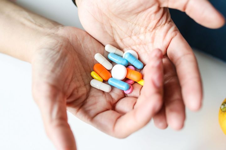 色とりどりのカプセルや錠剤を手のひらにのせたイメージ写真で、試験で使われた薬ではありません。試験では、どちらを飲んだかを、参加者にも症状を評価する医師にも伏せました。