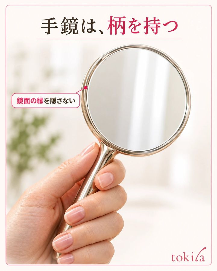 鏡面の丸い縁と、柄を支える指の位置