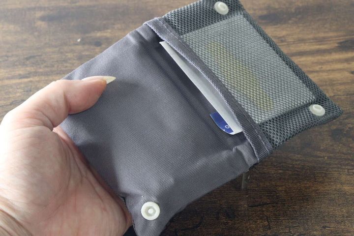 ボタン付きの折りたたみ構造になったメッシュポケットに絆創膏を入れている状態