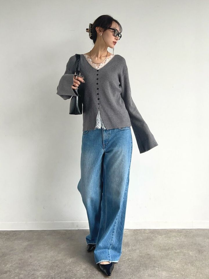 レースディテールのグレーカーディガンを着てバッグを持つ女性