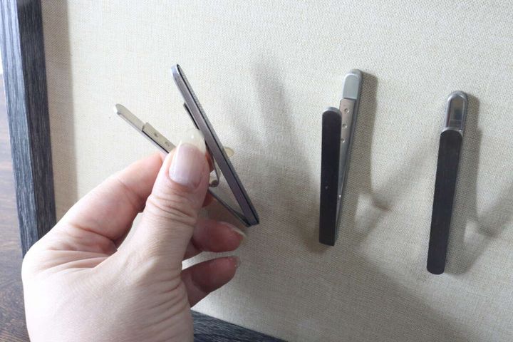 布貼りのボード部分にマグネットクリップを貼り付けて試している手元