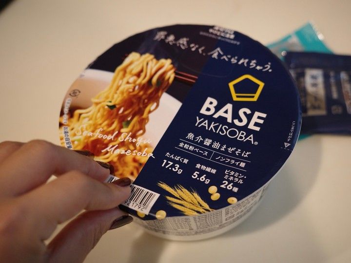BASE FOODのカップ焼きそばを開封する様子
