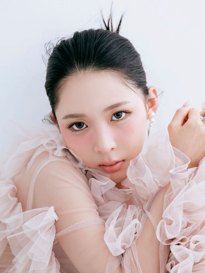 タイトシニヨンヘアで澄んだ表情を見せるモデルのミチさん