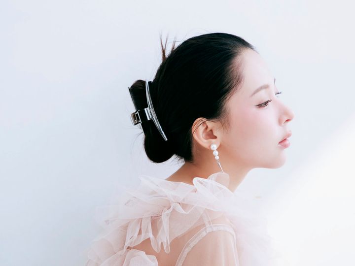 バンスクリップでまとめ、毛先を立たせたタイトシニヨンのサイドスタイル