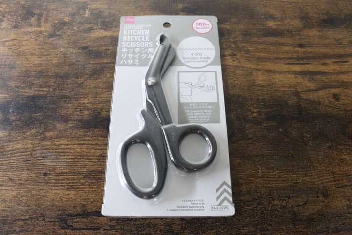 木製テーブルの上に置かれたパッケージ入りのキッチン用リサイクルハサミ