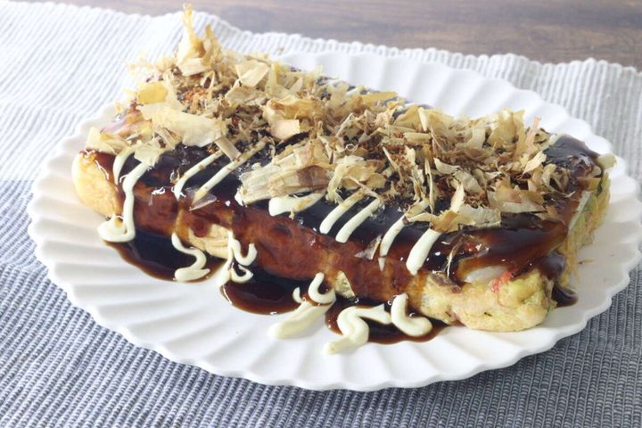 ソースとマヨネーズ、鰹節がたっぷりとかかった焼き上がったお好み焼き